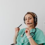 Profissional de saúde usando headset durante uma consulta médica on-line.