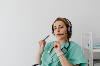 Profissional de saúde usando headset durante uma consulta médica on-line.