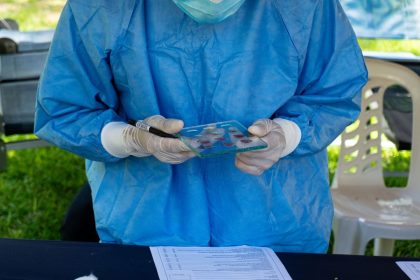 Profissional de saúde examina uma amostra de sangue durante uma ação de atendimento.