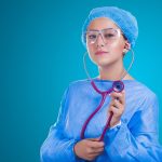 Profissional de saúde usando estetoscópio em ambiente hospitalar.